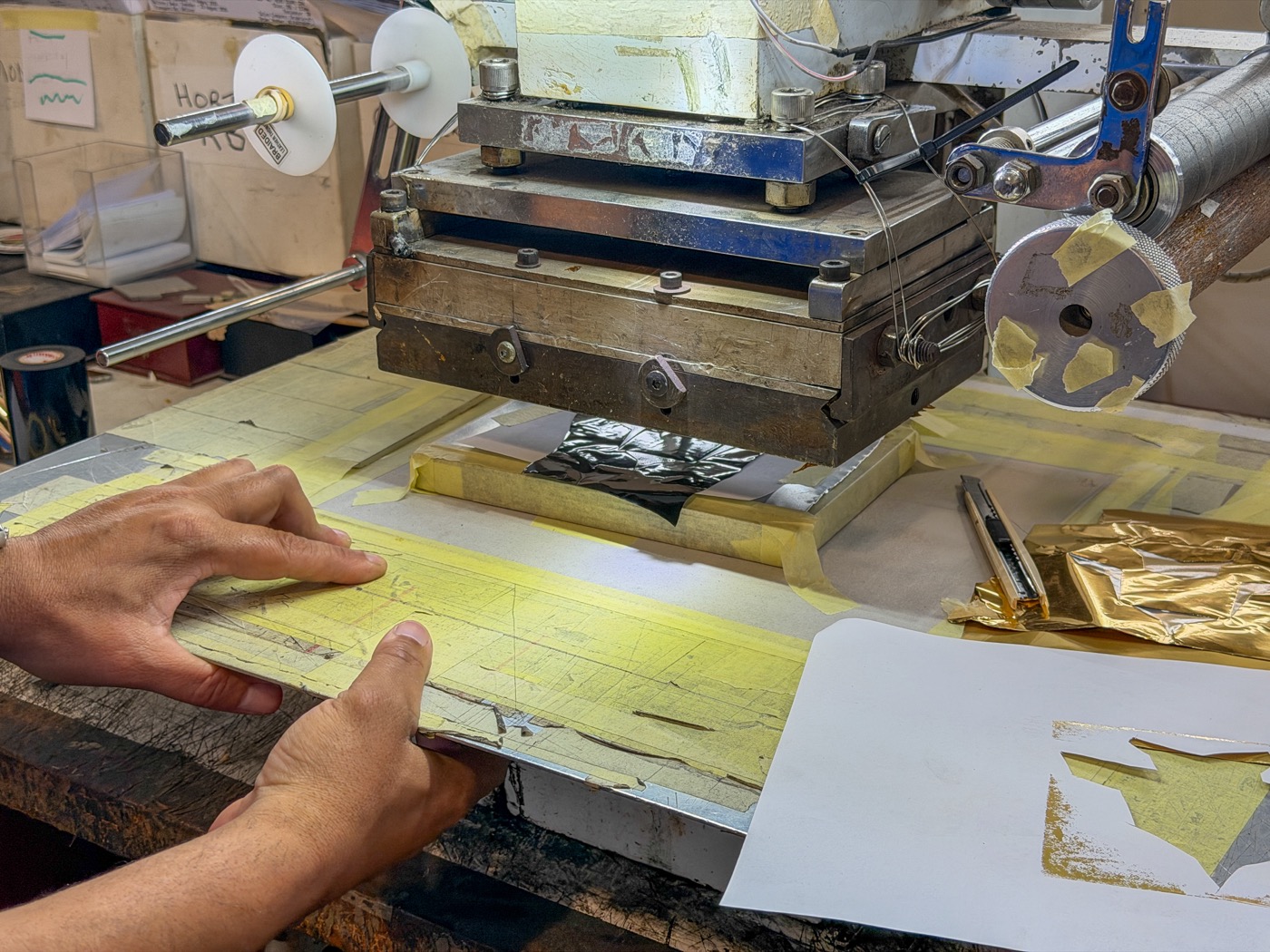 Hot foil press being loaded by hand