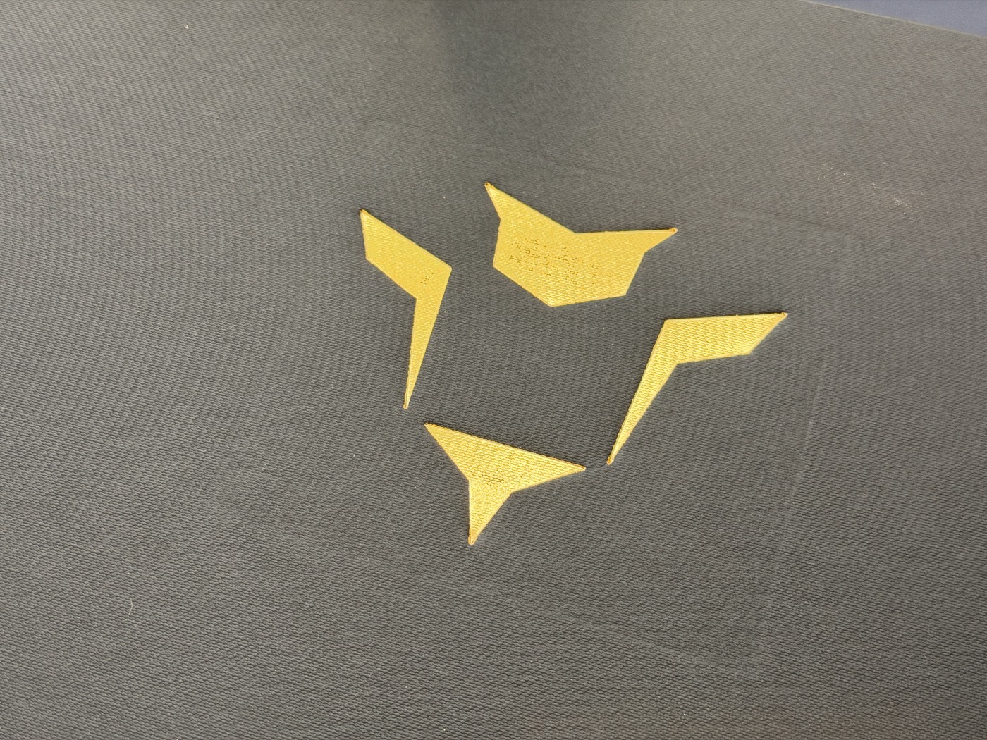 Gold foil shapes on a dark board